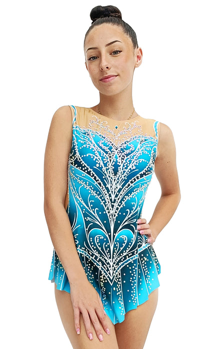 Este maillot deportivo destaca por su diseño en tonos azul degradado, decorado con líneas blancas y pedrería que simulan un elegante patrón floral. Tiene una malla nude en el escote con detalles brillantes y una falda corta en picos que acompaña el movimiento. Es una prenda sofisticada y perfecta para competición