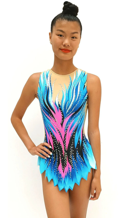 Maillot de gimnasia rítmica con diseño en tonos azules y rosas, decorado con pedrería brillante. Su corte en picos y fondo nude realzan la figura, aportando dinamismo, elegancia y movimiento en cada rutina. Ideal para destacar en competición.
